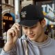 Black baseball cap with 'Just Here For The Snacks' raccoon graphic