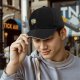 Black baseball cap with cute T-rex holding coffee graphic