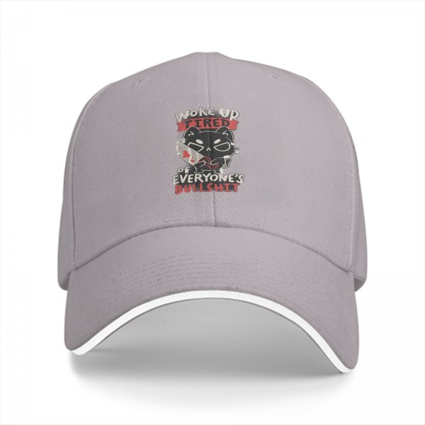 Black baseball cap with a tired cat graphic and humorous text