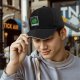 Black baseball cap with green 'DISOBEY' portrait graphic