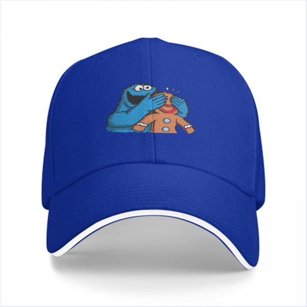 Black baseball cap with Cookie Monster covering a gingerbread man’s eyes