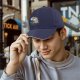 Black baseball cap with tangled orange cat and yarn it graphic