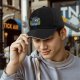 Black Baseball Cap With Cartoon Boys Crossing Stream Artwork