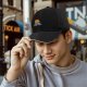 Black Baseball Cap With Grumpy Orange Cat Holding Mug Under Blanket Print