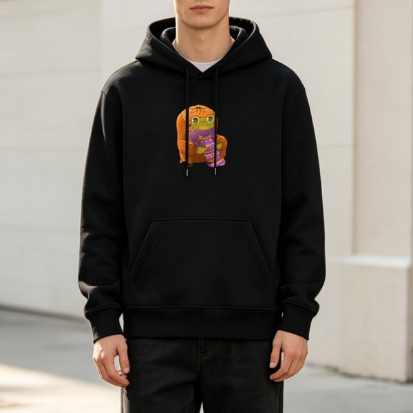 Black hoodie with a cute frog in pumpkin hat sitting on a chair graphic
