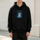 Black hoodie with a blue Christmas monster wearing a Santa hat and fairy lights