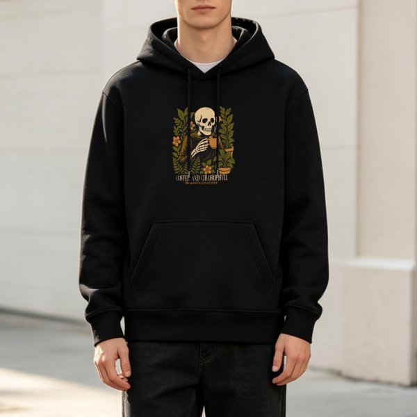 Black hoodie with skeleton holding coffee surrounded by plants
